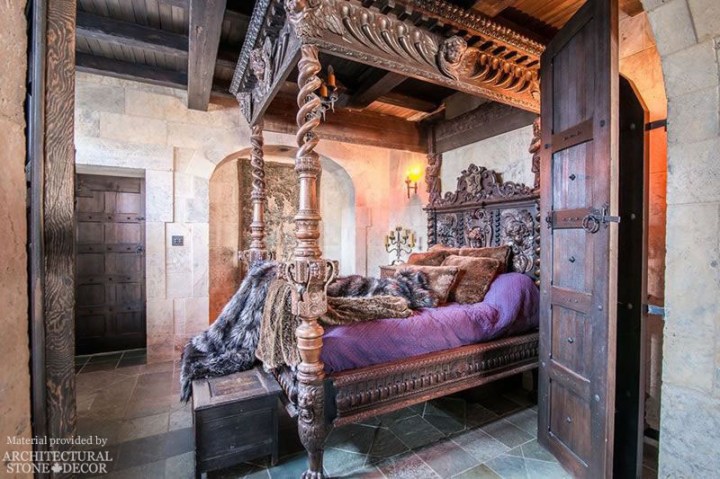 King's Landing Red Keep Medieval Game of Thrones bedroom with reclaimed limestone flooring and wall cladding and rustic wood doors and beams
