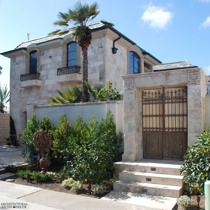 Coastal Mediterranean style villa home old world limestone entryway wall cladding wrought iron metal gate Canada Toronto