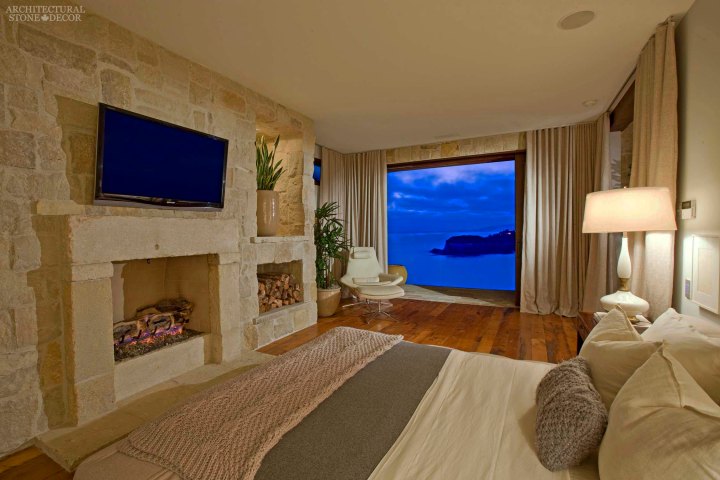 west coast style coastal mediterranean master bedroom reclaimed antiqued limestone hand carved fireplace mantel cladding Canada ca