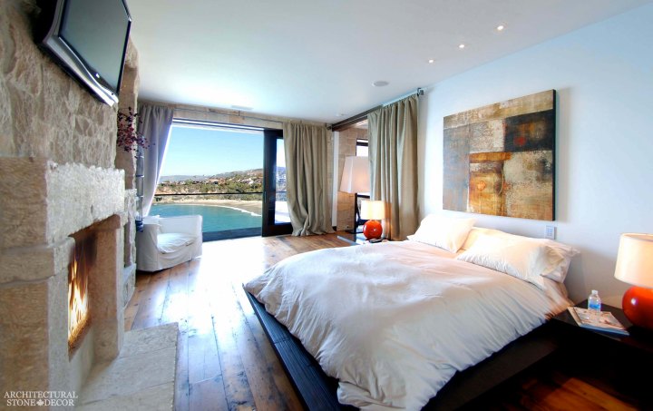 west coast style coastal mediterranean master bedroom reclaimed antiqued limestone handcarved fireplace mantel cladding canada ca