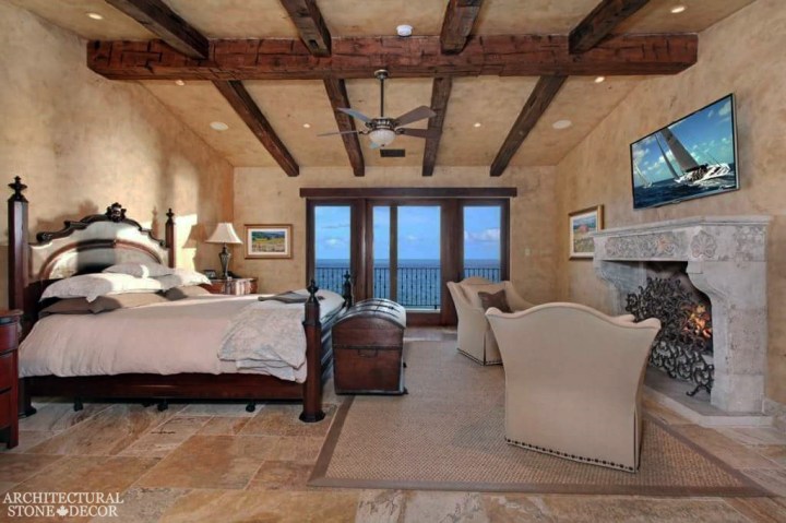west coast style coastal mediterranean master bedroom natural stone reclaimed antiqued limestone handcarved fireplace flooring Canada ca